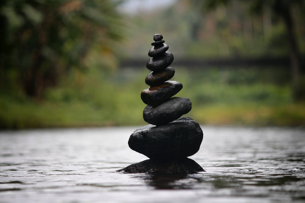 Balanced stones in a serene river evoke a sense of peace and tranquility.